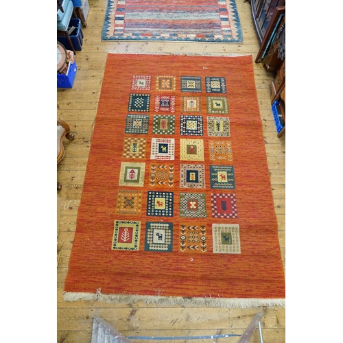 296 - A Turkish Red ground, square gul, fishtail design carpet with fringed edge. Measuring: