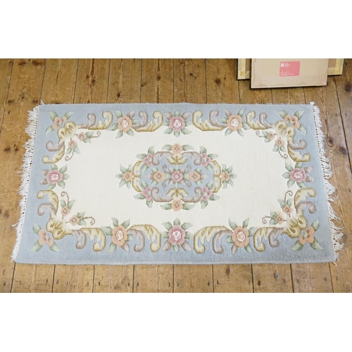 299 - An Indian Blue Ground Fringe Rug. Measuring: 136cms long x 75cms.