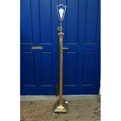 413 - A Brass Corinthian columned standard lamp resting on a gadrooned base with lion paw feet.