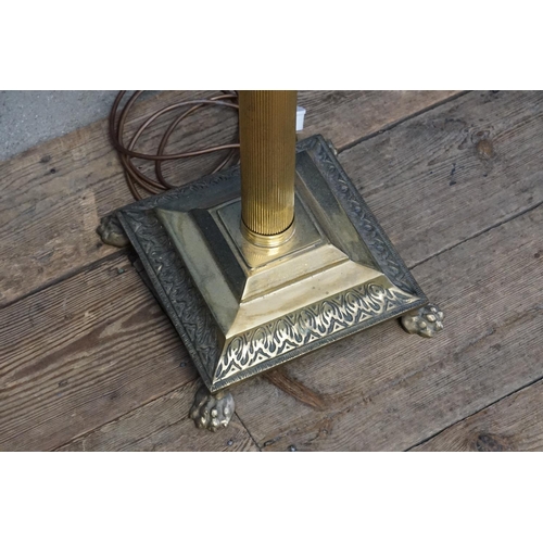 413 - A Brass Corinthian columned standard lamp resting on a gadrooned base with lion paw feet.