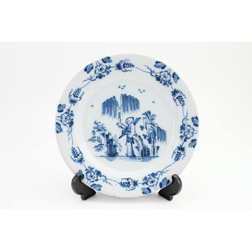 988 - An Antique blue and white Lambeth Delft tin glazed plate decorated with a scribe in a garden setting... 