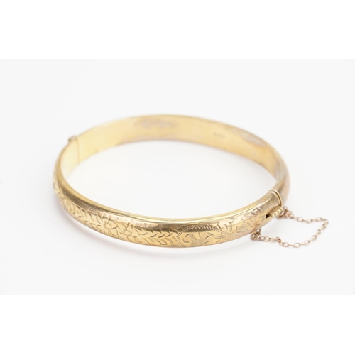 165 - A 9ct Gold engraved Bangle. Diameter: 5.5cms x 6.5cms. Weight: 11.8 grams.