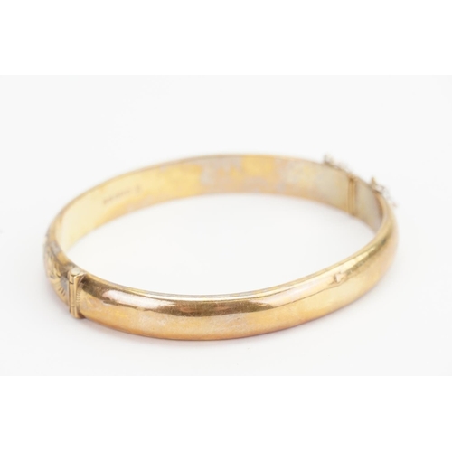 165 - A 9ct Gold engraved Bangle. Diameter: 5.5cms x 6.5cms. Weight: 11.8 grams.