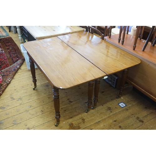 602 - A Georgian Mahogany Twin Pillared Dining Table Resting on Fluted Legs with Brass Castors, fitted wit... 