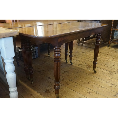 602 - A Georgian Mahogany Twin Pillared Dining Table Resting on Fluted Legs with Brass Castors, fitted wit... 
