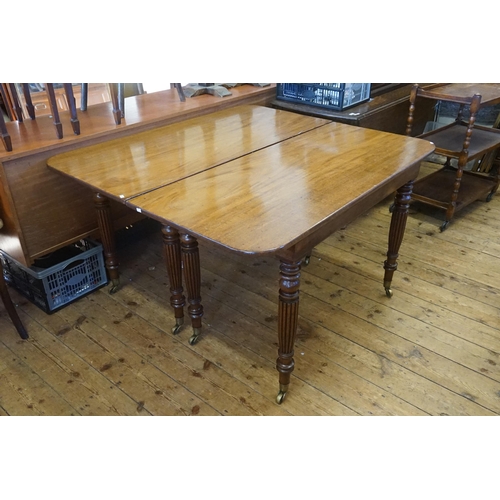 602 - A Georgian Mahogany Twin Pillared Dining Table Resting on Fluted Legs with Brass Castors, fitted wit... 