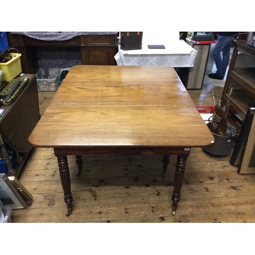 602 - A Georgian Mahogany Twin Pillared Dining Table Resting on Fluted Legs with Brass Castors, fitted wit... 
