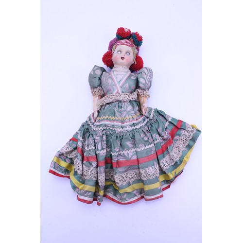 544 - An Early Dressed Doll with a Bisque Head, Fixed Blue Eyes & Original Dress. Measuring: 50cms.