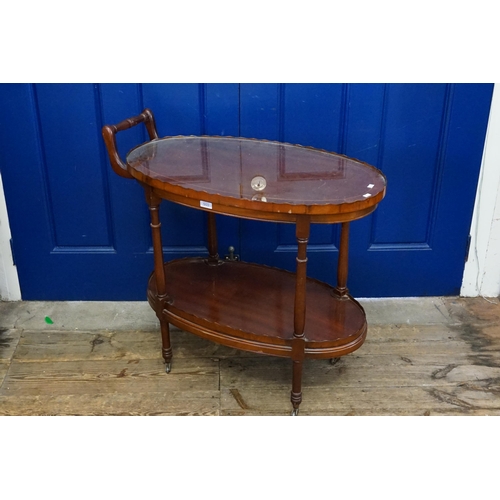 579 - A Reproduction Oval Mahogany & inlaid Reception Drinks Trolley on Castors. Measuring: 78cms long x 4... 