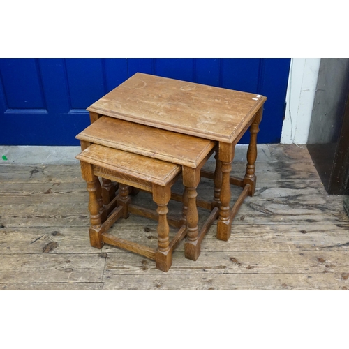 642 - A Nest of Three Graduated Oak Coffee Tables resting on turned legs. Measuring: 63cms long x 43cms de... 