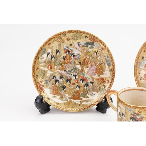 767 - A Pair of Satsuma designed Coffee Cans & Saucers decorated with many figures in garden & Room settin... 