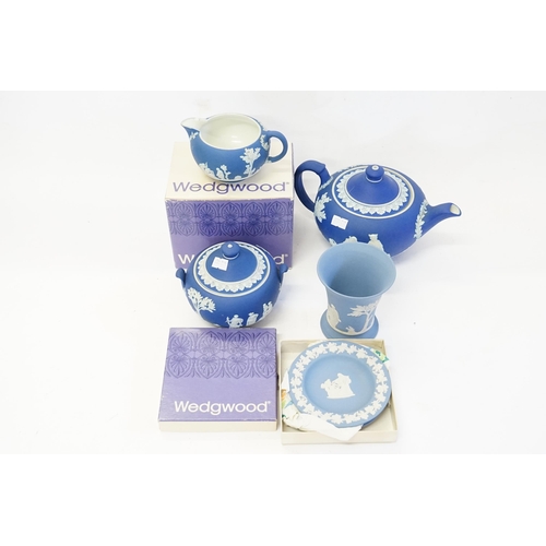 527 - A Wedgwood Blue Slip Ware Classical decorated Squat Tea Pot, Sugar Bowl, Cream Jug along with two ot... 