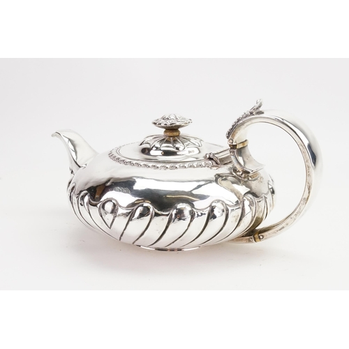 31 - A Georgian Silver Squat Melon Shaped Tea Pot with a Flying Scroll Handle & a Gadrooned Decoration. M... 