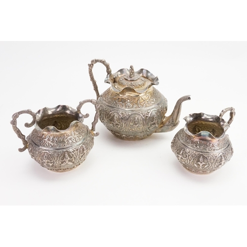 63 - An Indian embossed Deity decorated Tea Set with Floral decoration to include a Tea Pot, Sugar Bowl &... 