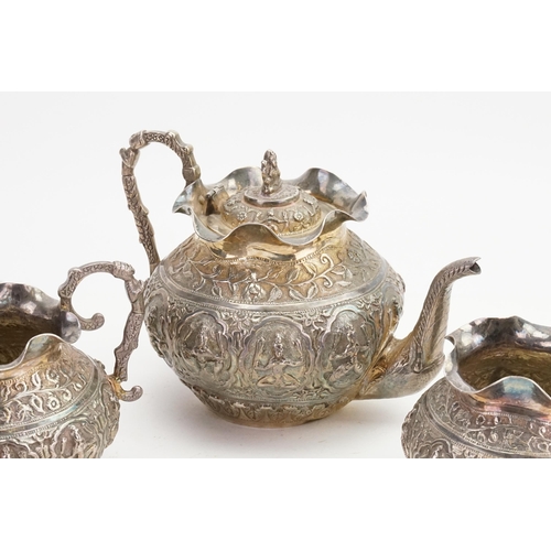 63 - An Indian embossed Deity decorated Tea Set with Floral decoration to include a Tea Pot, Sugar Bowl &... 