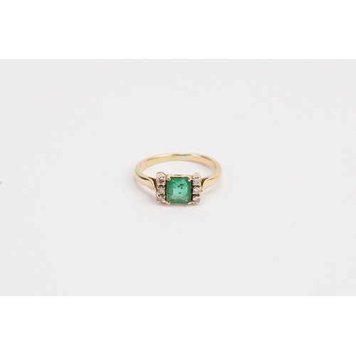 217 - A 18ct Emerald and Diamond set ring, set with 6 chip stones. Size of Emerald 5.3mm x 5.9mm. Ring siz... 