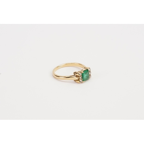 217 - A 18ct Emerald and Diamond set ring, set with 6 chip stones. Size of Emerald 5.3mm x 5.9mm. Ring siz... 