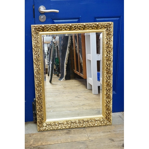 821 - A Gilt Framed Mirror decorated with Flowers. Measuring: 64cms x 87cms.