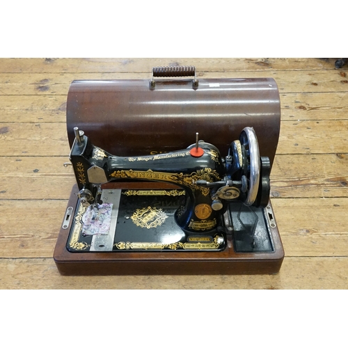 1030 - A Singer sewing machine contained in oak case.