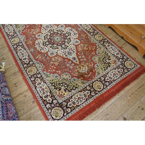 664 - A Burgundy Ground Central Medallion Wide Bordered Corner decorated Rug with Fringe. Measuring: 240cm... 