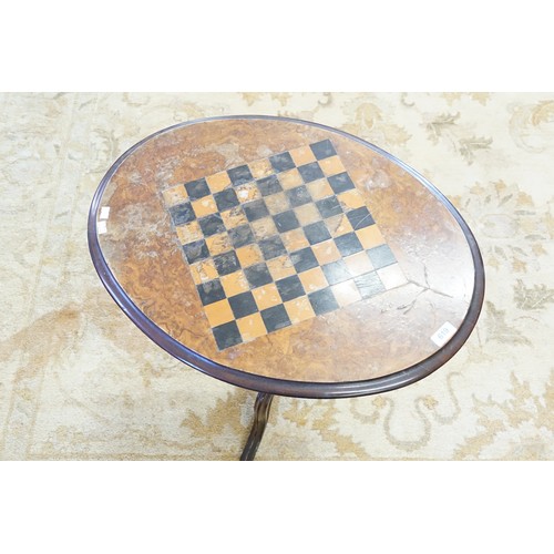 619 - A Victorian Walnut Veneered Oval Chess Top Table resting on a Tripod Base. Measuring: 61cms x 46cms ... 