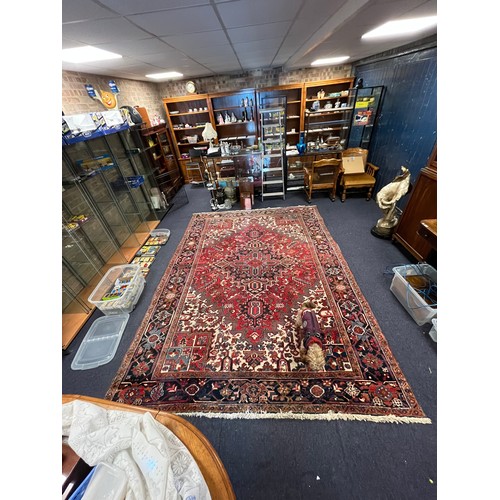 663A - A large red ground and beige rug. Measuring 242cm  x 339cm.