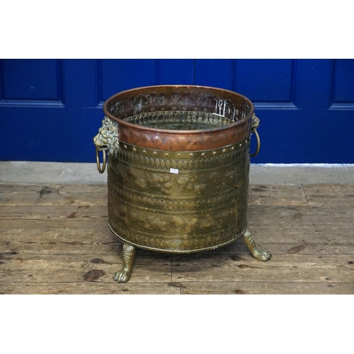 579 - A Dutch Brass & Copper embossed Log Basket restring on Pad Feet. Measuring: 42cms across x 44cms hig... 