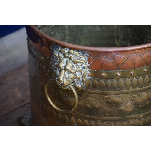 579 - A Dutch Brass & Copper embossed Log Basket restring on Pad Feet. Measuring: 42cms across x 44cms hig... 