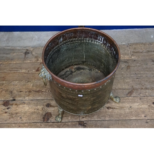 579 - A Dutch Brass & Copper embossed Log Basket restring on Pad Feet. Measuring: 42cms across x 44cms hig... 