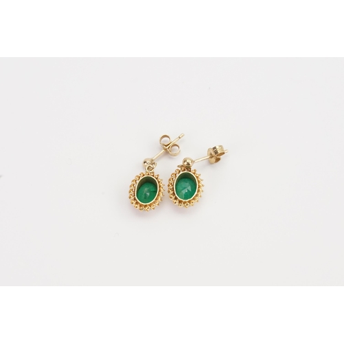 82 - A 9ct Gold pair of ladies Emerald earrings in the drop design. Weight 1.6g. 0.7ct size.