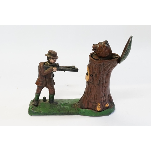 588 - A 20th Century Cast Iron Money Box Toy depicting a Man Shooting a Bear coming out of a tree stump.