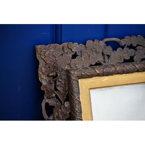 558 - A Victorian Carved Wooden Framed Mirror with an Oak Leaf & Acorn Edge. Measuring: 73cms x 87cms.