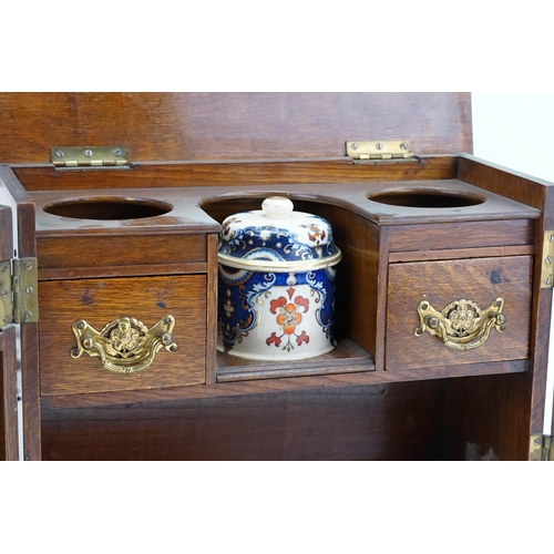 702 - A Late 19th Century Oak Lift-Top Two Drawers Pipe Rack Tobacco Cabinet with a Pottery Tobacco Box. M... 