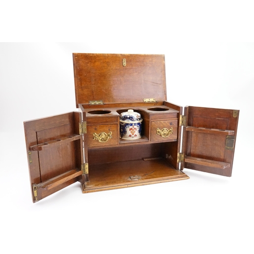 702 - A Late 19th Century Oak Lift-Top Two Drawers Pipe Rack Tobacco Cabinet with a Pottery Tobacco Box. M... 