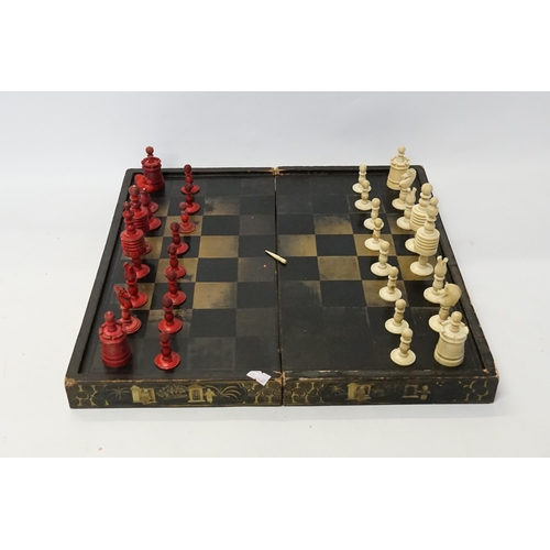 609 - A Chinese Black Lacquered & Decorated Folding Chess Board containing a selection of Bone Chess Piece... 