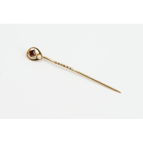 164 - A 15ct marked Ruby and pearl set stick pin. Weight 1.3g