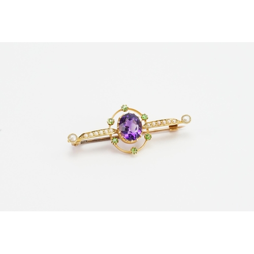 197 - A 15ct yellow gold bar brooch with a claw set oval Amethyst (7mm x 8.7mm). Set with six 2mm round pe... 