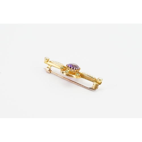 197 - A 15ct yellow gold bar brooch with a claw set oval Amethyst (7mm x 8.7mm). Set with six 2mm round pe... 