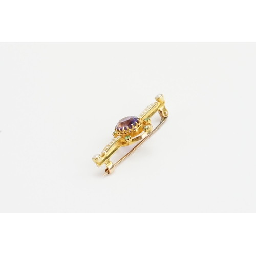 197 - A 15ct yellow gold bar brooch with a claw set oval Amethyst (7mm x 8.7mm). Set with six 2mm round pe... 