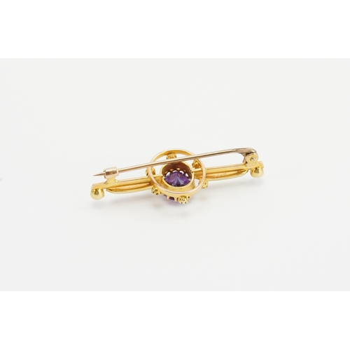 197 - A 15ct yellow gold bar brooch with a claw set oval Amethyst (7mm x 8.7mm). Set with six 2mm round pe... 