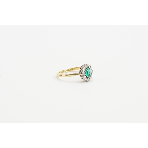 199 - A 18ct Gold and Platinum topped ring, set with a oval cut Emerald and eight 0.03ct surrounding diamo... 