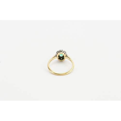 199 - A 18ct Gold and Platinum topped ring, set with a oval cut Emerald and eight 0.03ct surrounding diamo... 