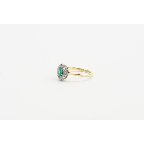 199 - A 18ct Gold and Platinum topped ring, set with a oval cut Emerald and eight 0.03ct surrounding diamo... 