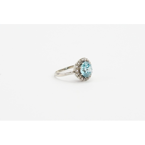 202 - A 9ct white gold cluster style ring, set with a brilliant cut natural bright blue zircon (approx 2.2... 