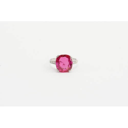 203 - A platinum cushion cut synthetic ruby ring, set with chip diamonds on the shoulders. Weight 4.5g.