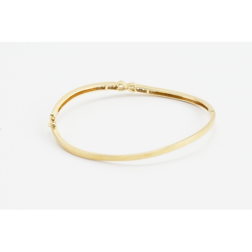 228 - A 18ct yellow gold diamond set bangle, in the eternity design. Set with eight diamonds, approx 0.02c... 