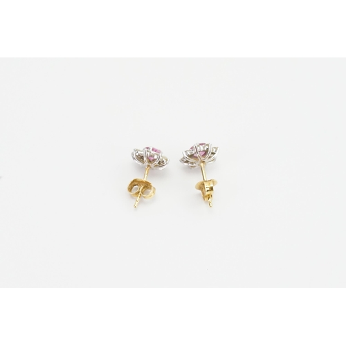 230 - A pair of 18ct gold diamond and pink sapphire earrings, in the floral design, set with eight diamond... 