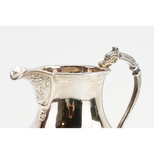 68 - A 1960 Adie Brothers Ltd silver cream jug, with decorated edge and dragon handle. Weight 138g.