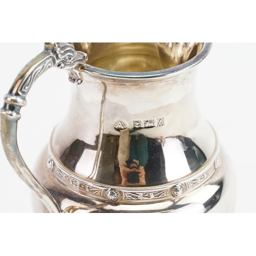 68 - A 1960 Adie Brothers Ltd silver cream jug, with decorated edge and dragon handle. Weight 138g.