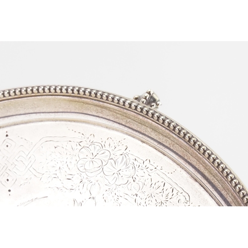 71 - A 1882 silver Edward Ker Reid salver, with bead edge decoration, and floral design. Resting on claw ... 